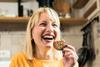 Joyful woman eating biscuit
